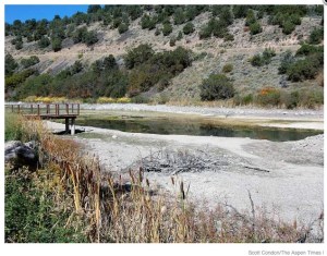 The low water level in Lake Christine exposes the bottom of the reservoir and keeps a fishing pier high and dry. The state is determining how high the water level can go without saturating an adjacent hillside -- photo / Scott Condon