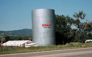 The Sedalia Water Tank was constructed in 1890 by the Santa Fe Railroad and served as a water supply for the locomotives until diesel supplanted the use of coal-fired steam engines.  Today, the water tank serves as the main water supply for Sedalia.  The tank was listed on the National Register of Historic Places in 2002 for its role during the steam era of the rail system and for its contributions to Colorado history. Photo via Douglas County.