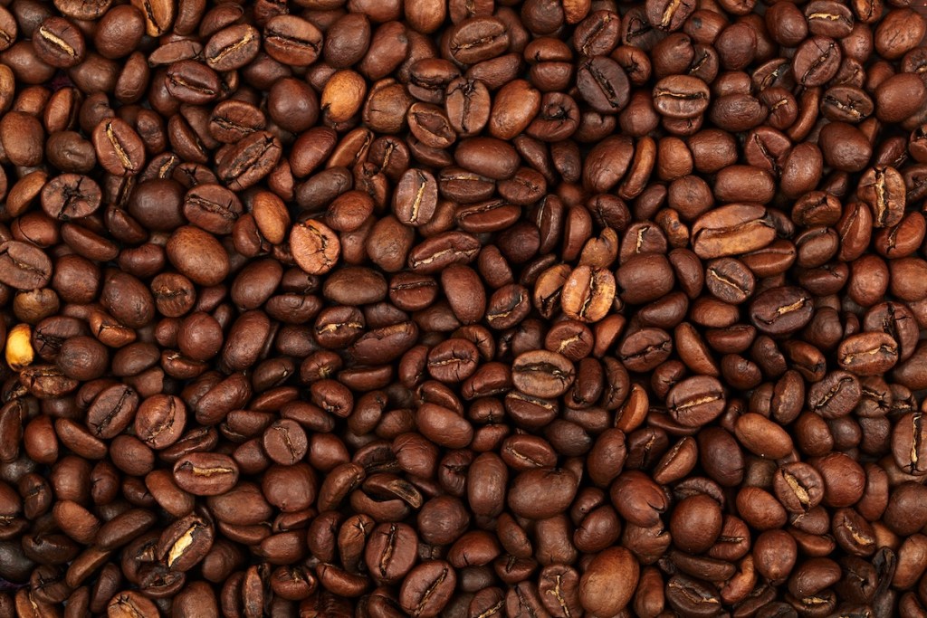 Close-up view of a variety of dark roasted coffee beans scattered on a surface.